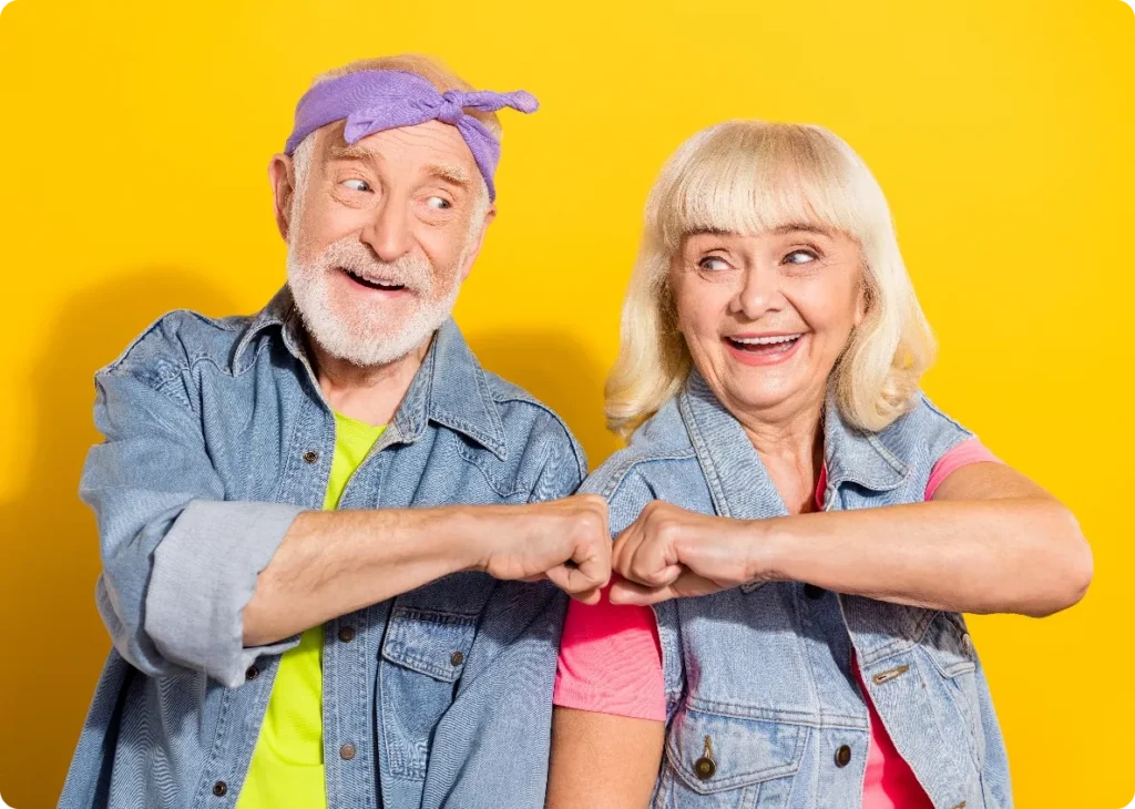 Couple de vieilles personnes habillées comme des rockeus et se faisant un check avec les poings