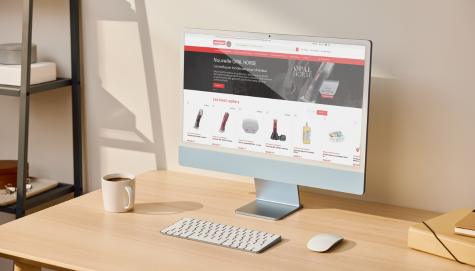 Site Heiniger affiché sur l'écran d'ordinateur sur un bureau en bois