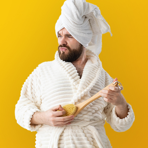 Homme avec peignoir jouant avec une brosse à cheveux