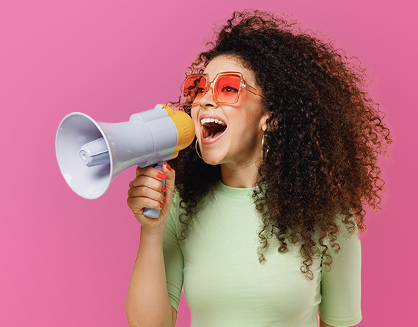 Femme avec mégaphone sur fond rose.