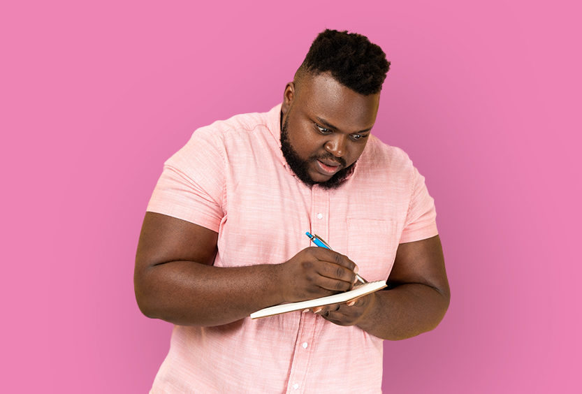 Homme écrivant sur un carnet.